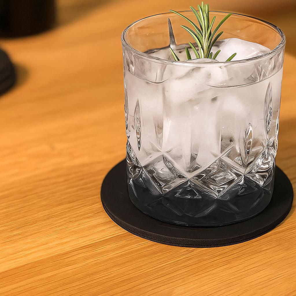 Glas mit Eis und Rosmarin auf einem schwarzen Glasuntersetzer aus Leder auf hellem Holz, Modell DEXTER