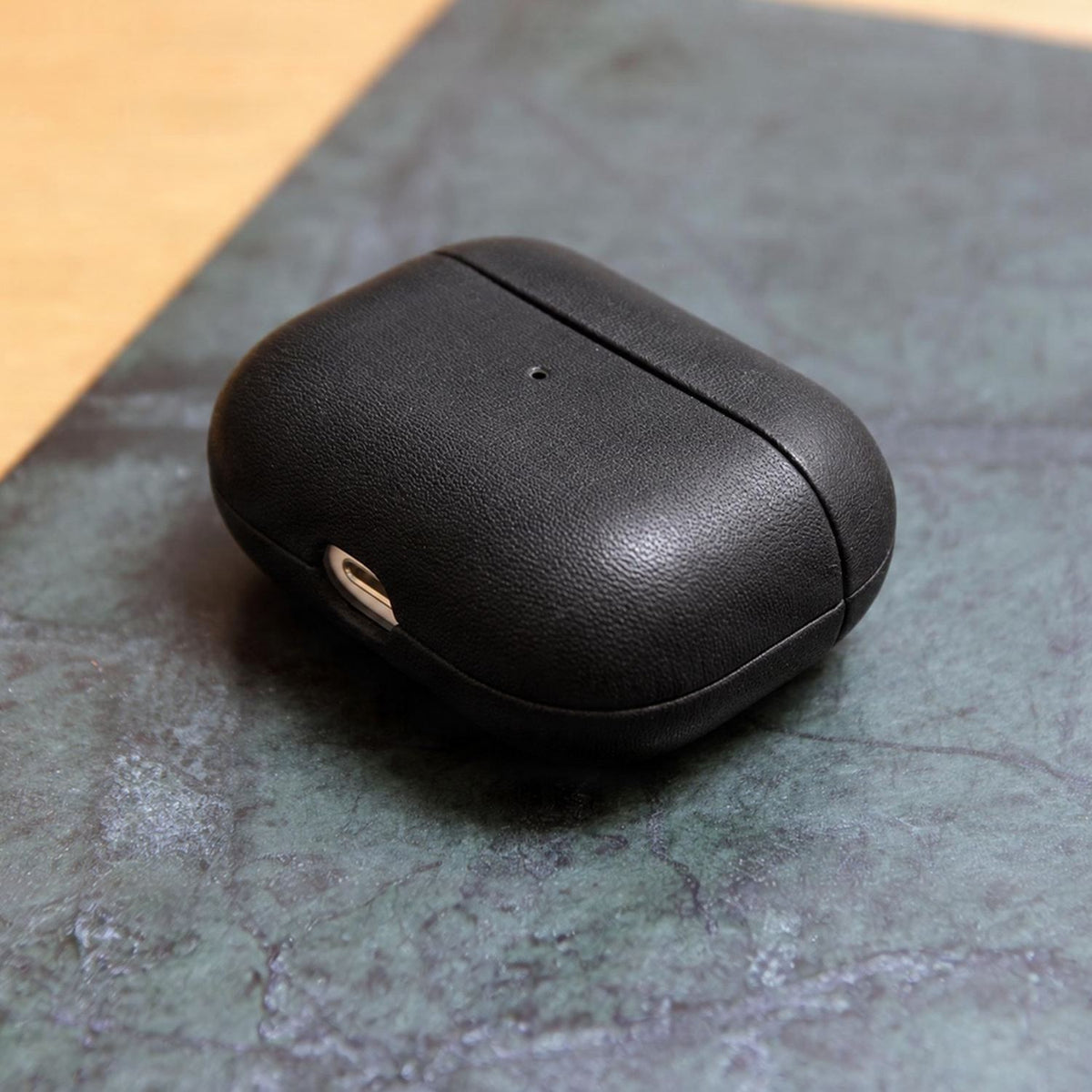 Schwarze AirPods Hülle aus Leder auf dunkler Schieferplatte, die AirPods liegen bereit, Modell OTLEY