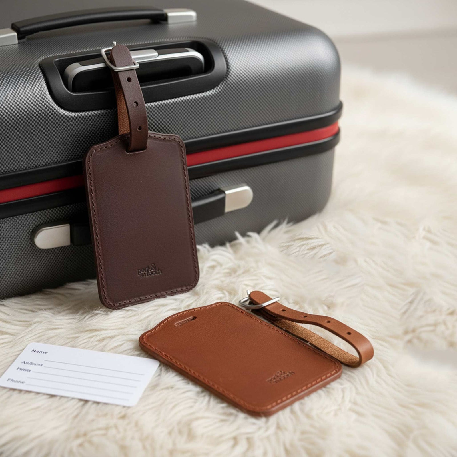 Leather luggage tags in light brown and dark brown attached to a trolley. Made in Germany